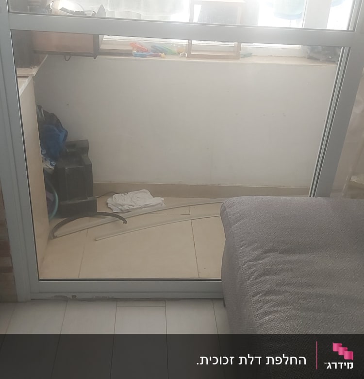 חלון זכוכית עם מסגרת מתכת, וילון בצד ימין